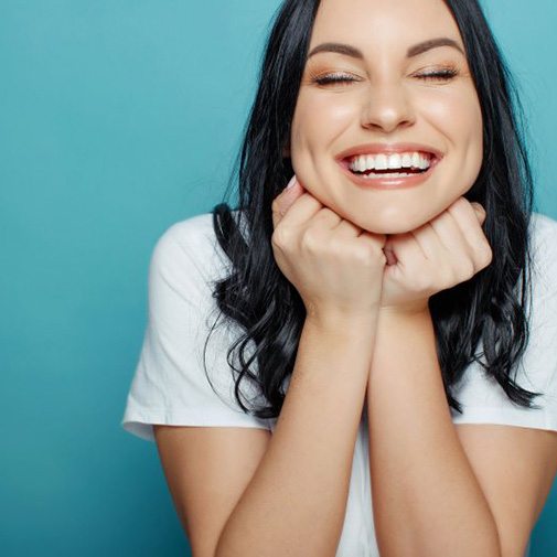 Woman smiling and resting her chin in her hands