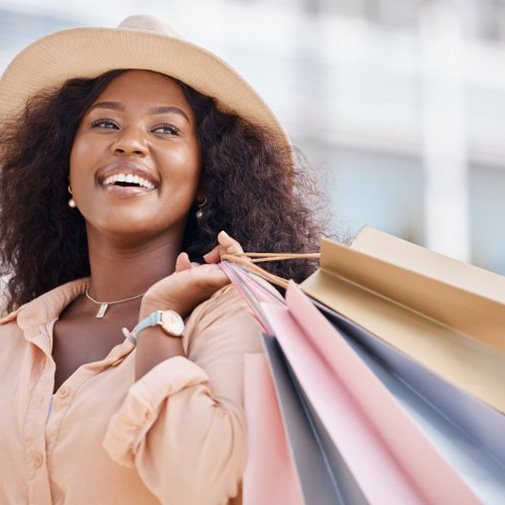Woman holding several shopping bags and smiling