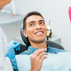 Patient smiling at dentist with pink mirror