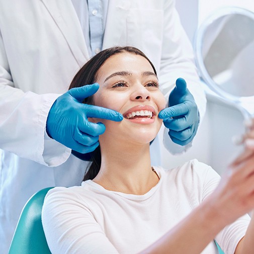 Dentist touching corners of smiling patient’s mouth