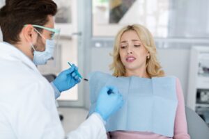 Woman about to receive dental treatment looking fearful and worried.